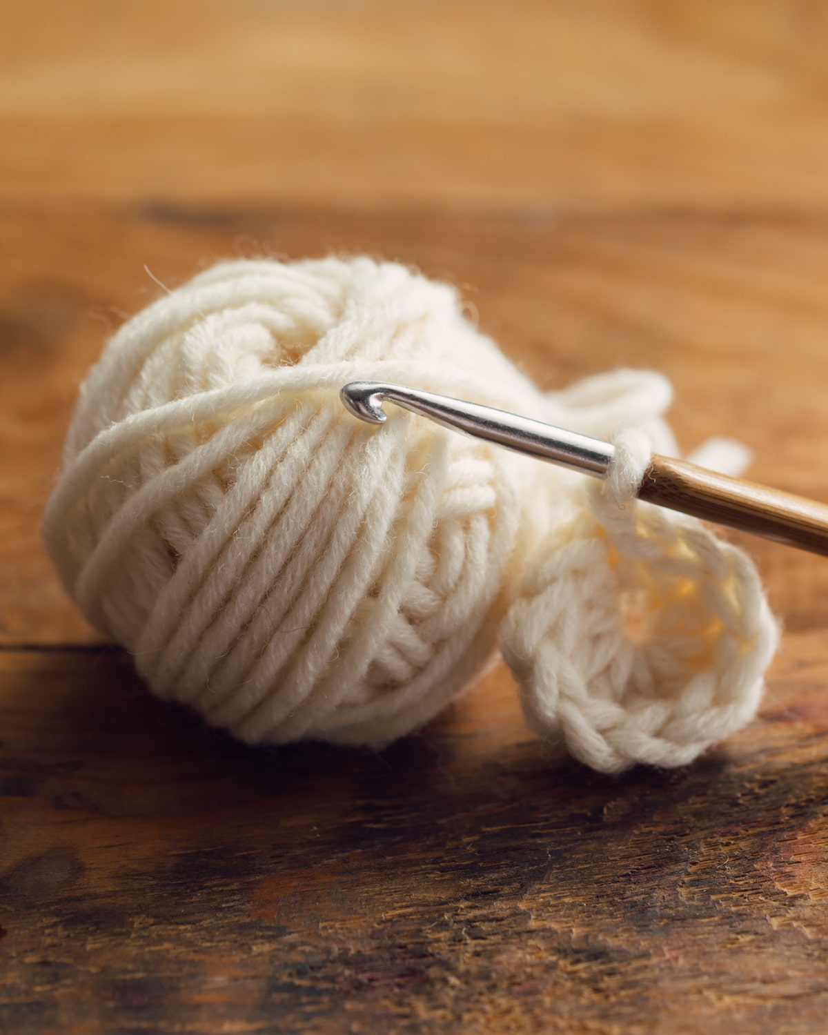 yarn and a crochet hook on a wooden table