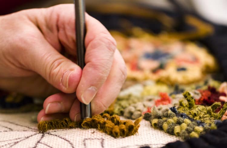 a person doing rug hooking