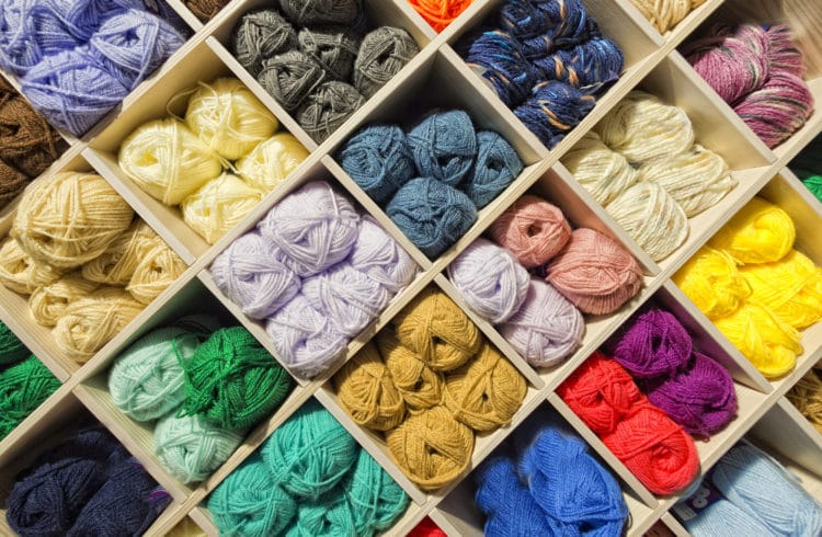 Different colors of yarn on shelves