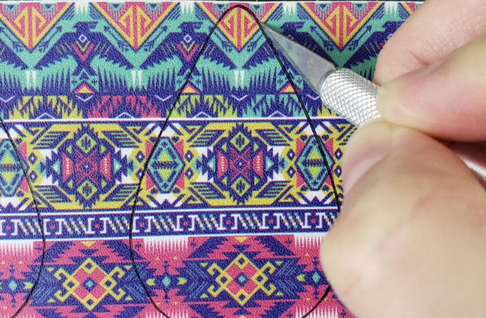 Cutting out leather earring with exacto knife
