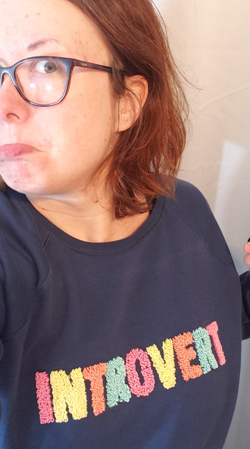 Me marveling at my handiwork on the punch needle sweatshirt