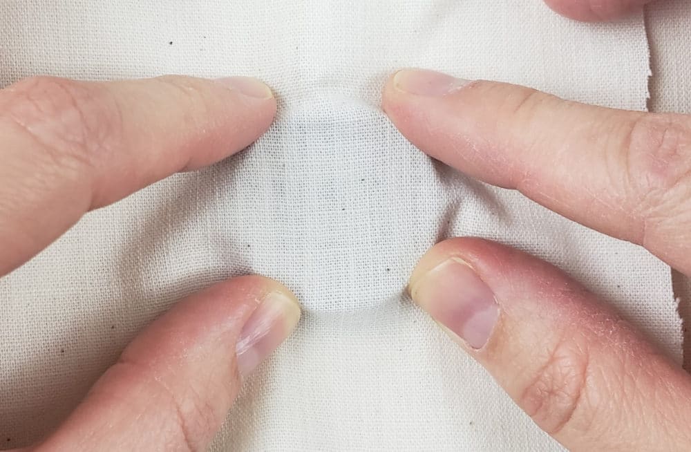 Put wooden bezel under your weaver's cloth | DIY Punch Needle Earrings
