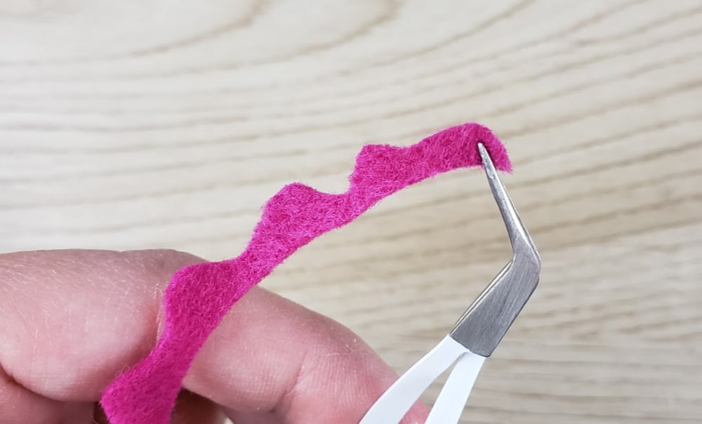 Holding the end of the felt flower with Cricut tweezers