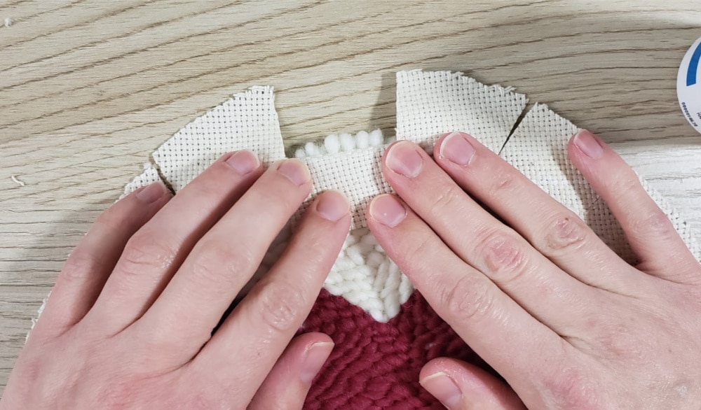 Fold over the tabs on the back of the punch needle trivet