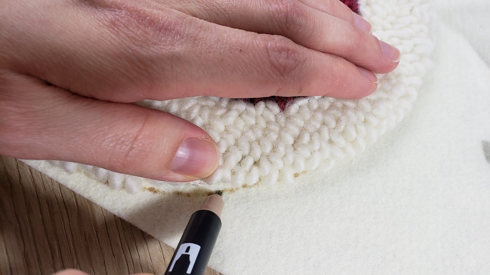 Tracing line around punch needle trivet onto felt