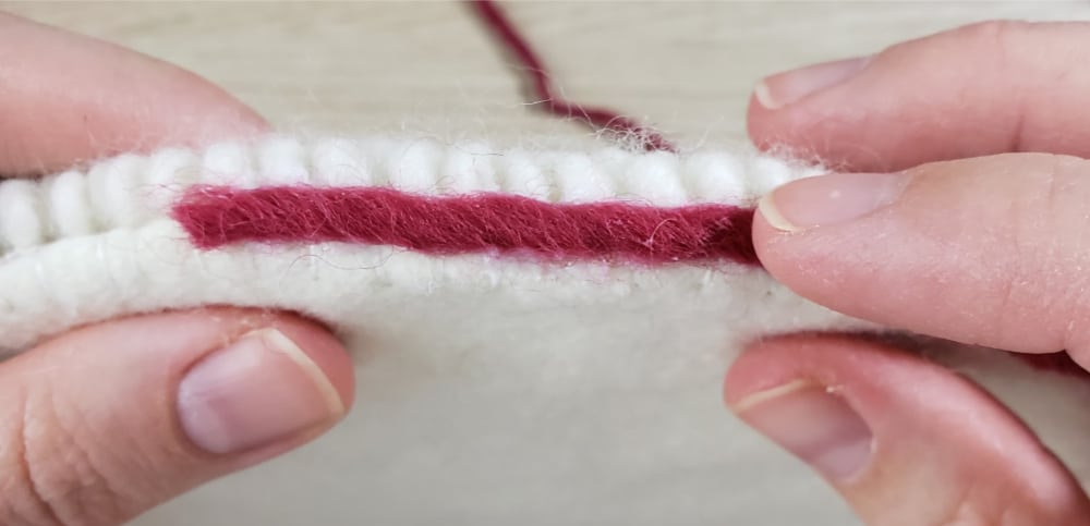 Press wool yarn onto fabric glue for border trim