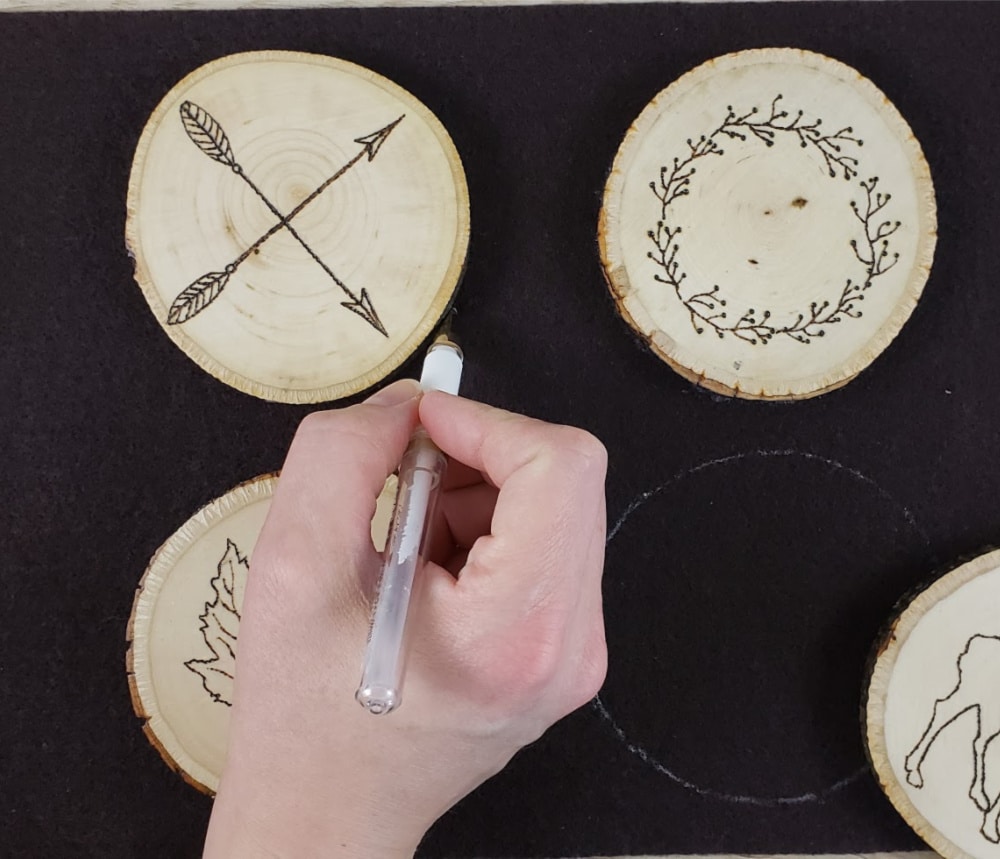 Outlining wood burned coasters for felt backings