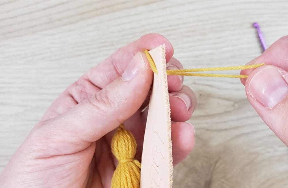 Attaching yarn tassel to DIY leather bookmark