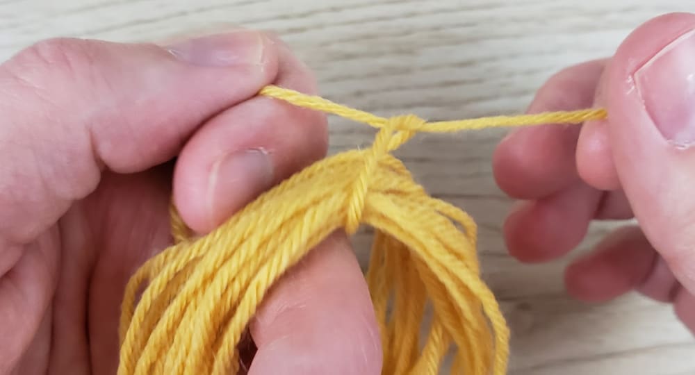 Tying yarn around DIY Yarn tassel