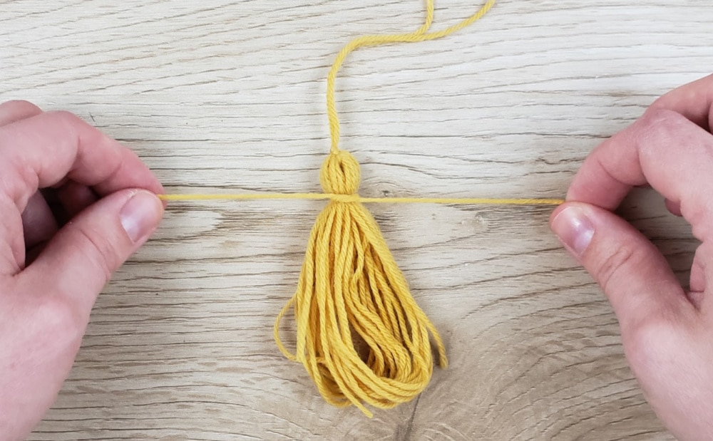 Tying yarn on tassel for DIY Leather Bookmark