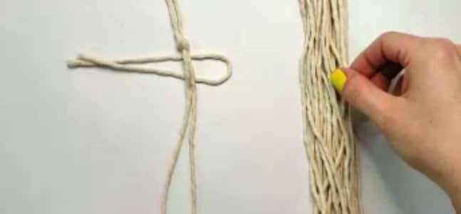 Lay the first piece of string under the spine of the macrame feather