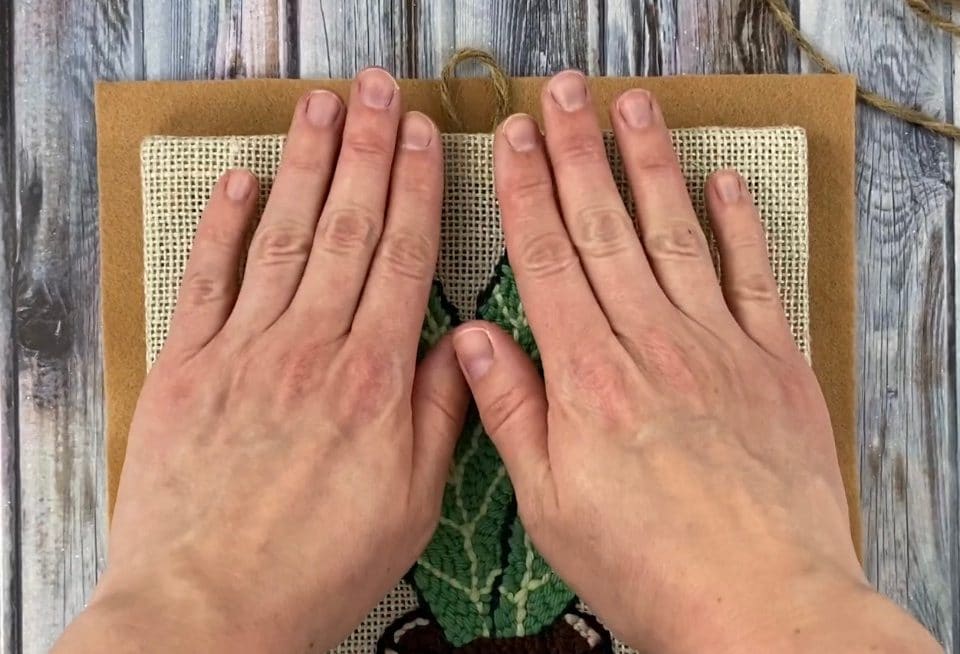 Press punch needle frame onto felt