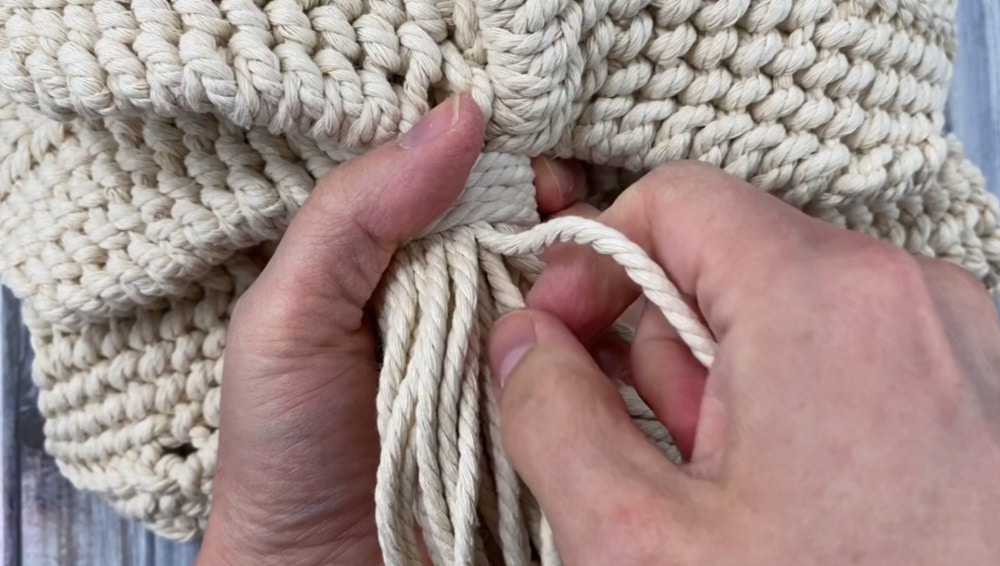 pull the strings under the wrapping knot to tighten the macrame flower