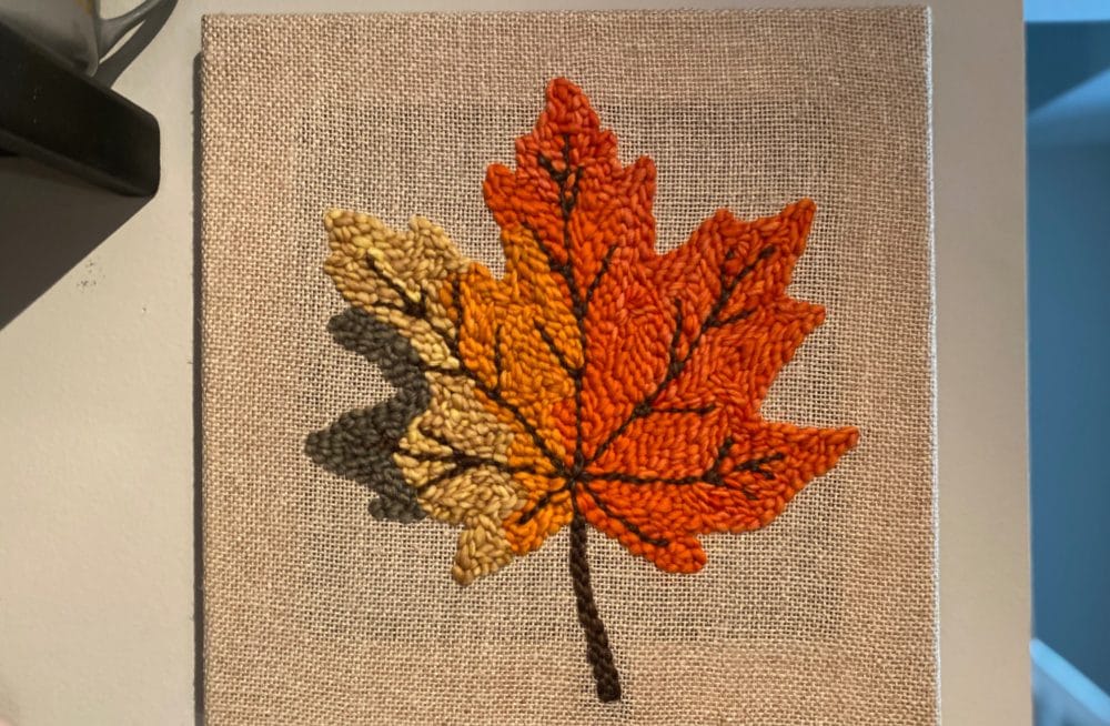 Finished maple leaf punch needle wall hanging on the wall