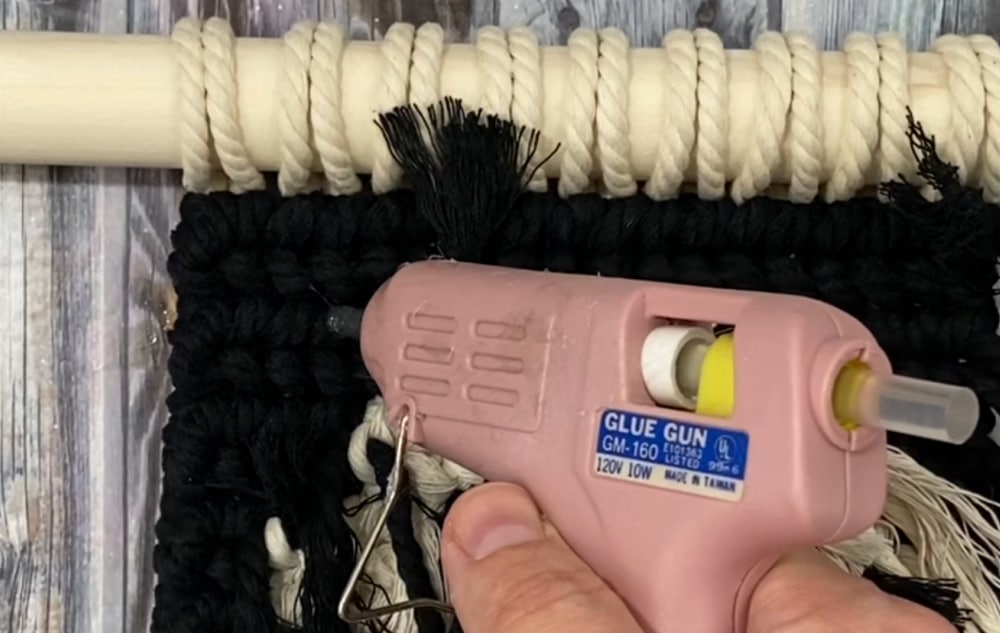 hot gluing the ends down on the back of macrame ghost