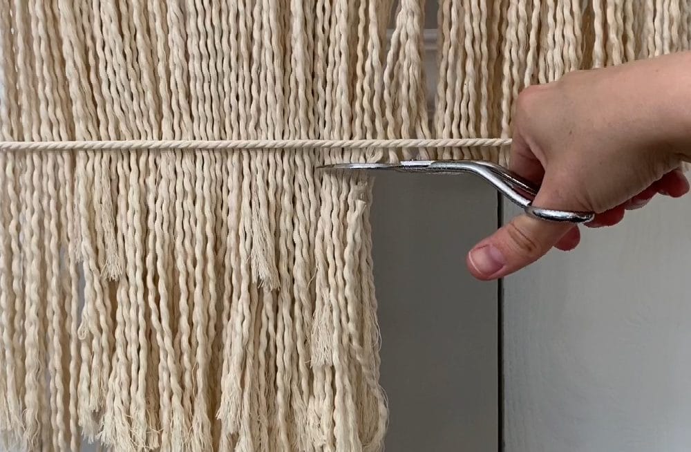 cutting off the bottom fringe from the macraweave