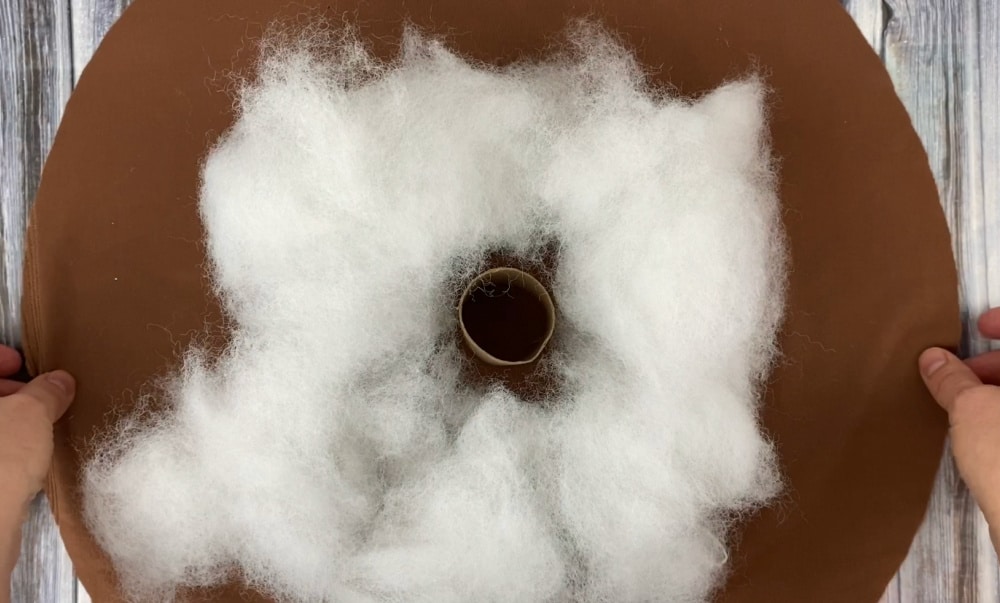 add the poly fil stuffing and the cardboard tube to the center of the velvet circle