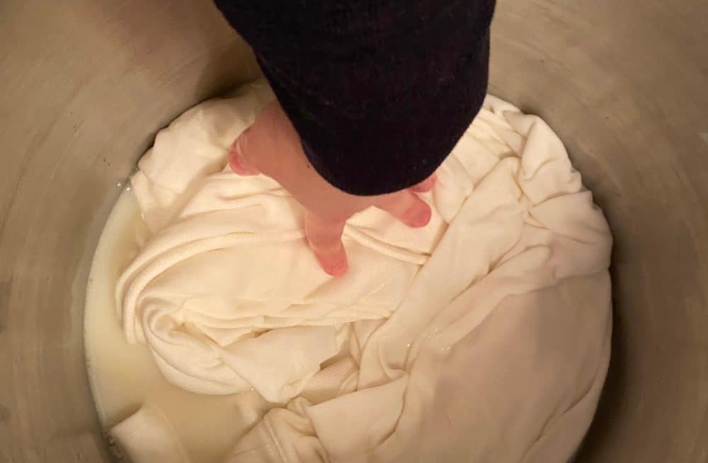 soaking the cotton hoodie in soy milk mordant prior to tie dyeing with avocados