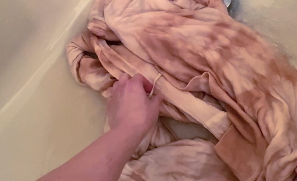 rinsing the tie dye hoodie under cold water