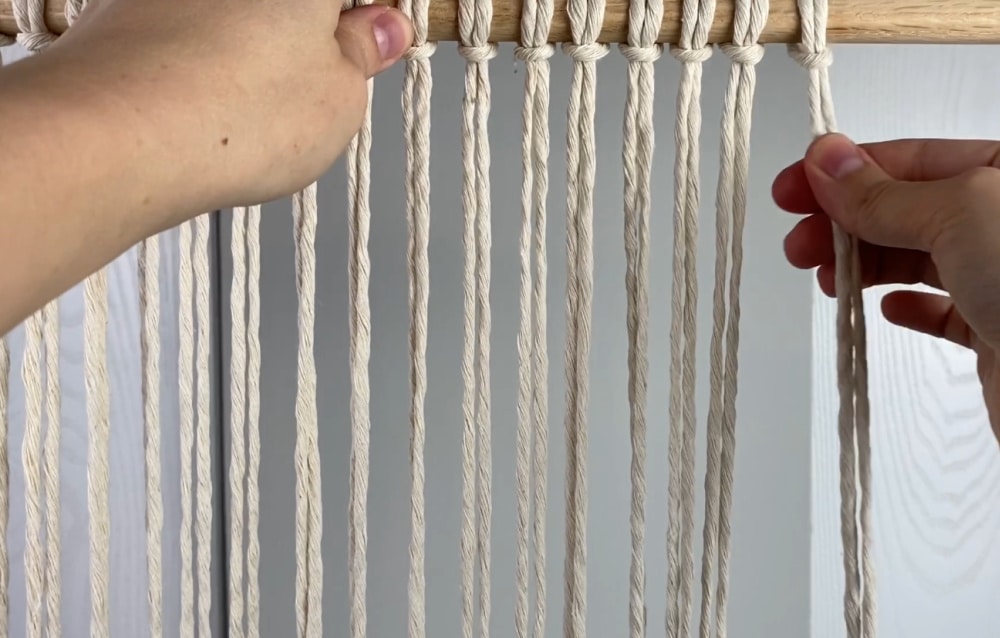 attach the cords to the dowel with larkshead knots | macrame placemat
