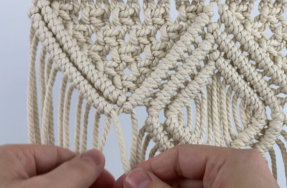 tying diagonal double half hitch knots on a small macrame wall hanging