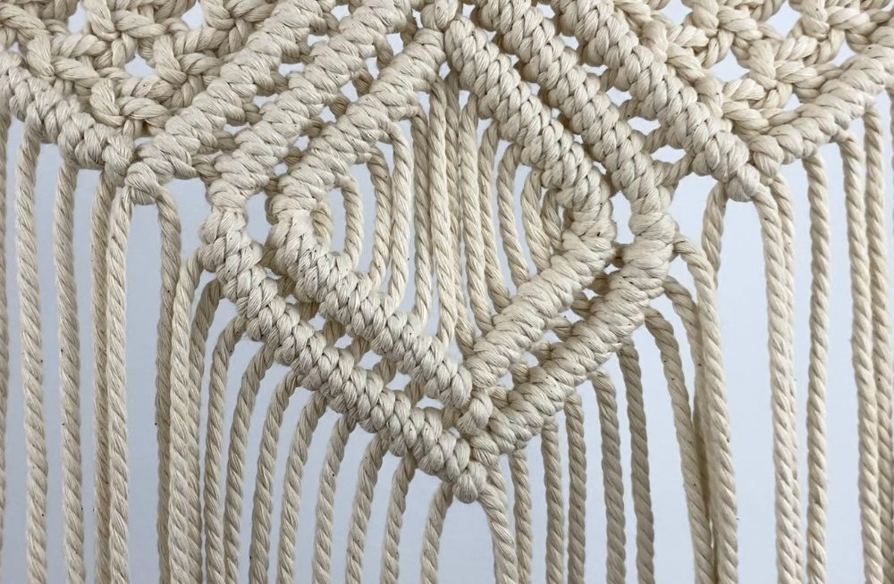 tying diagonal double half hitch knots on a small macrame wall hanging