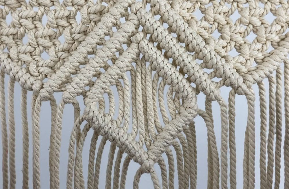 tying diagonal double half hitch knots on a small macrame wall hanging