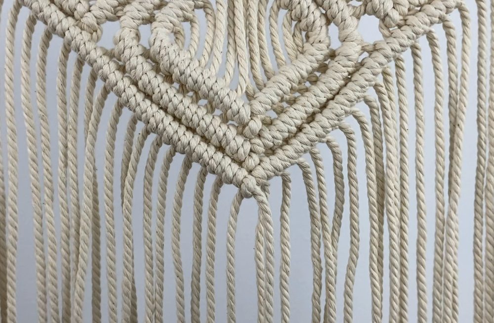 tying diagonal double half hitch knots on a small macrame wall hanging