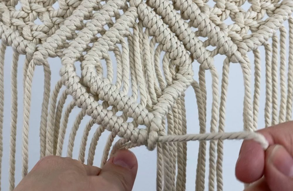 tying diagonal double half hitch knots on a small macrame wall hanging