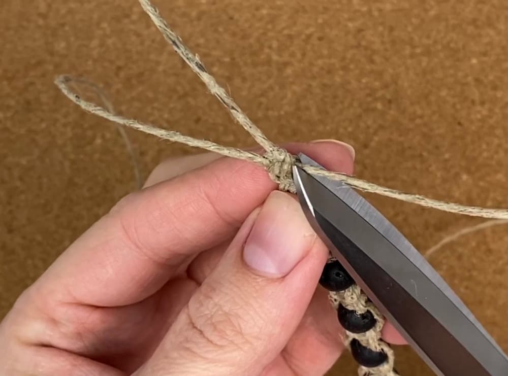 Cutting the ends of the working cords close to the glued knot