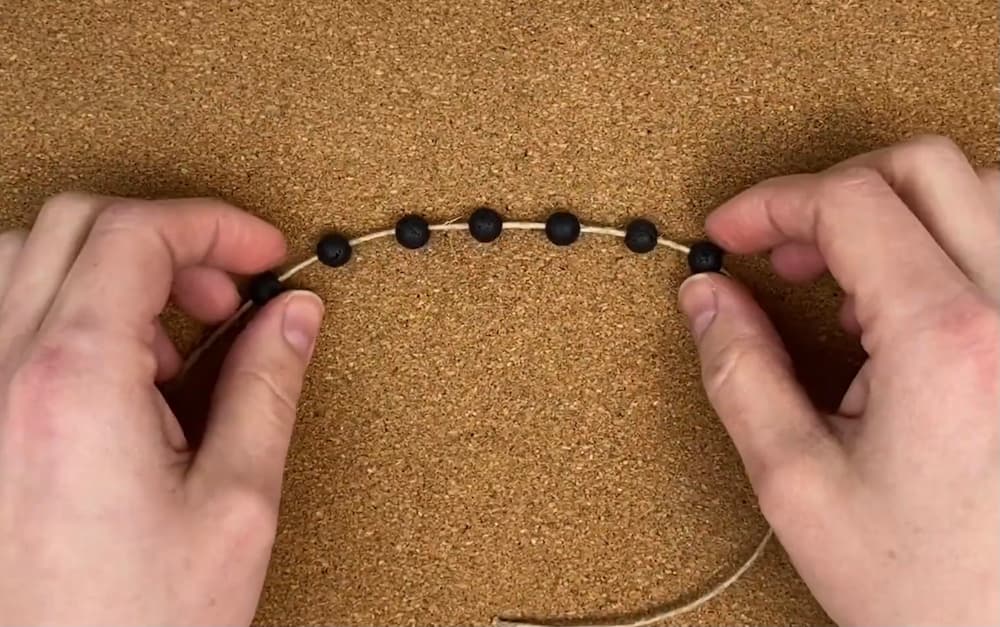 string the 7 beads onto the center cord of your macrame hemp bracelet