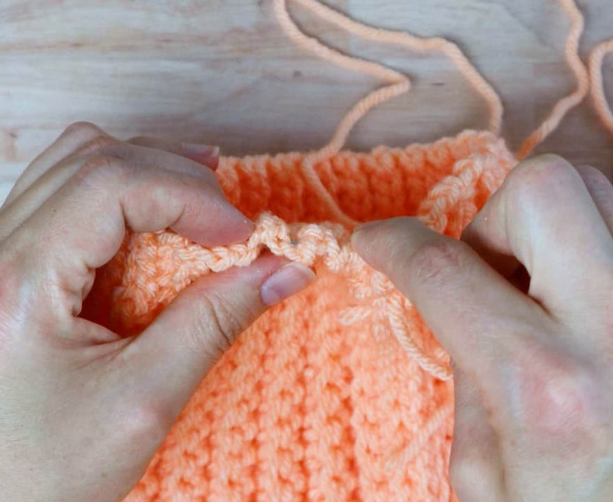 running stitch to gather the top of the crochet hat