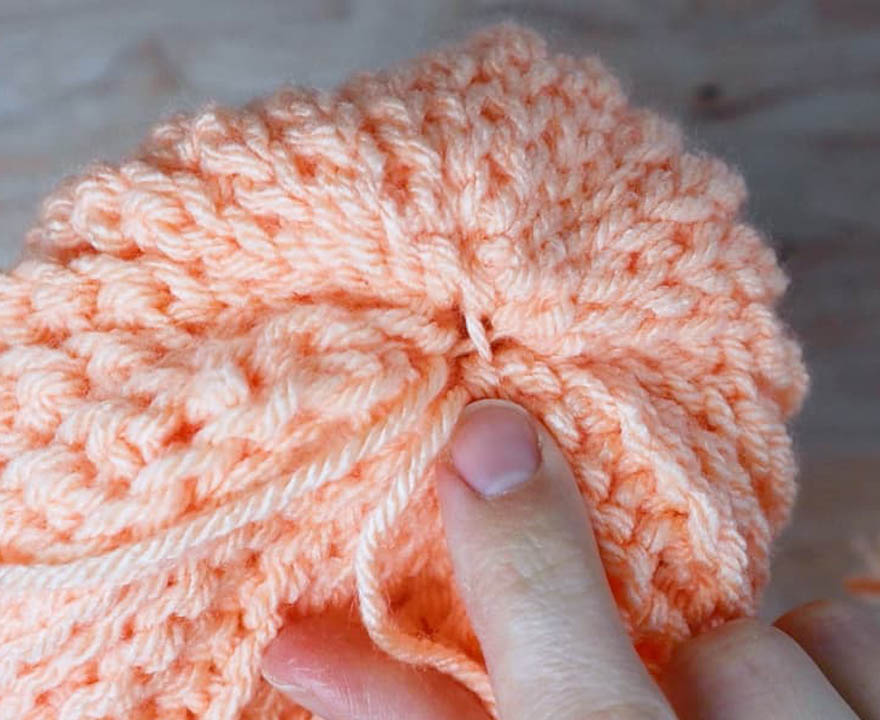 cross stitches at the top of the crochet beanie