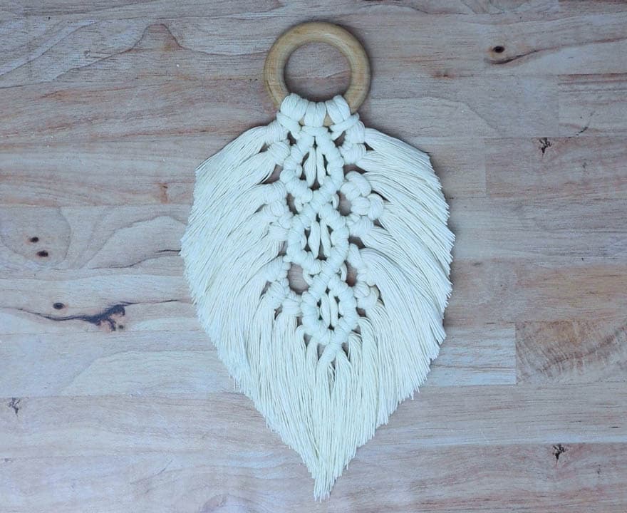 finished macrame feather with wooden ring