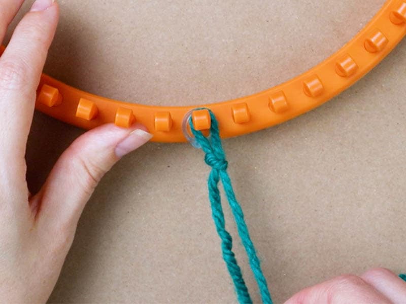 make a slip knot and put it on the peg with the stitch marker
