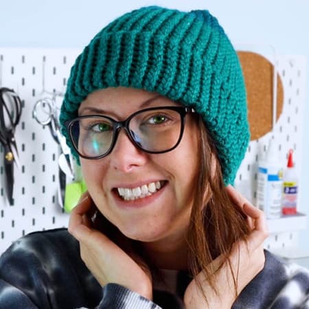 Crystal from Marching North modeling the adult size loom knit hat