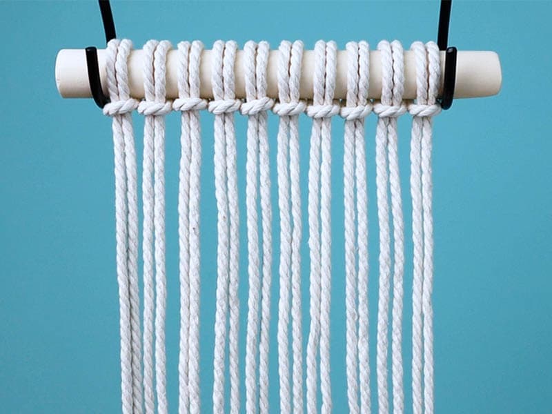 attach cords to the dowel with lark's head knots