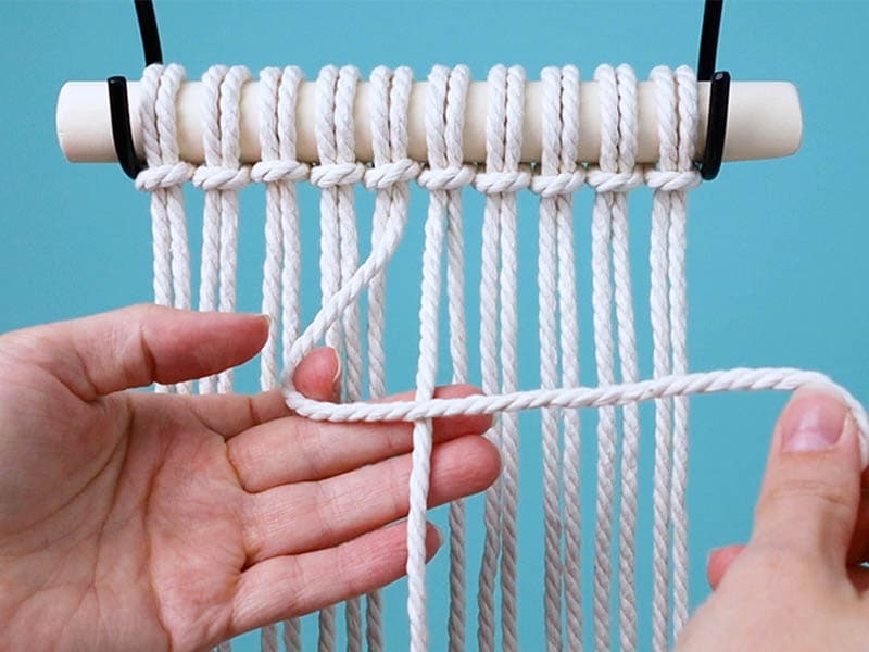 cross the left center cord over the right center cord in the shape of a number four