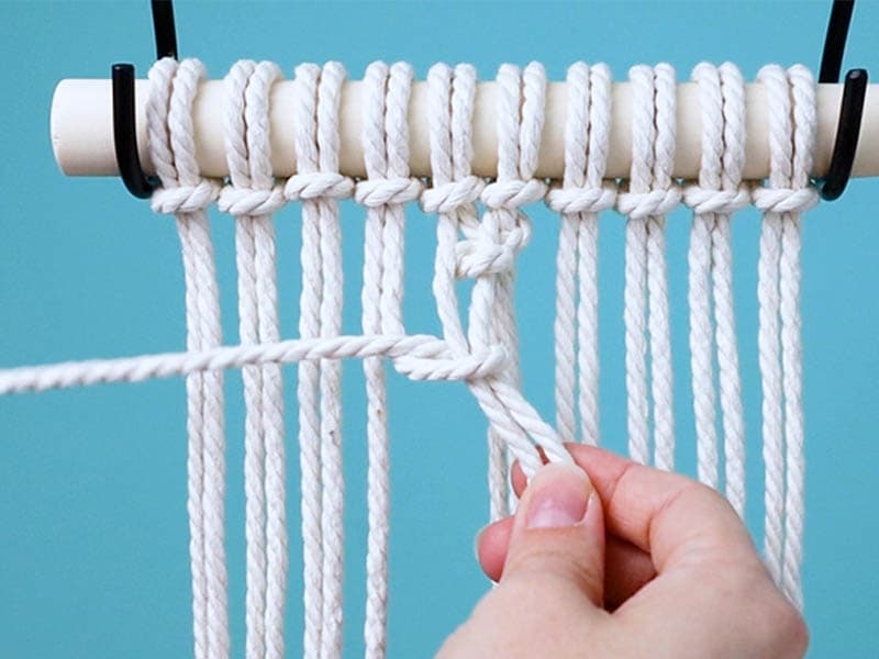 make a half hitch knot around two cords on the left side