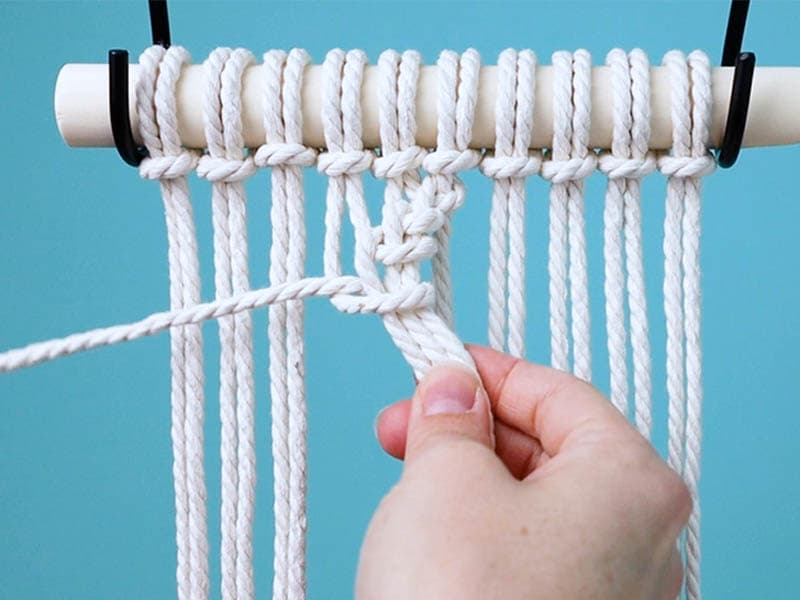 make a half hitch knot around three cords on the left side