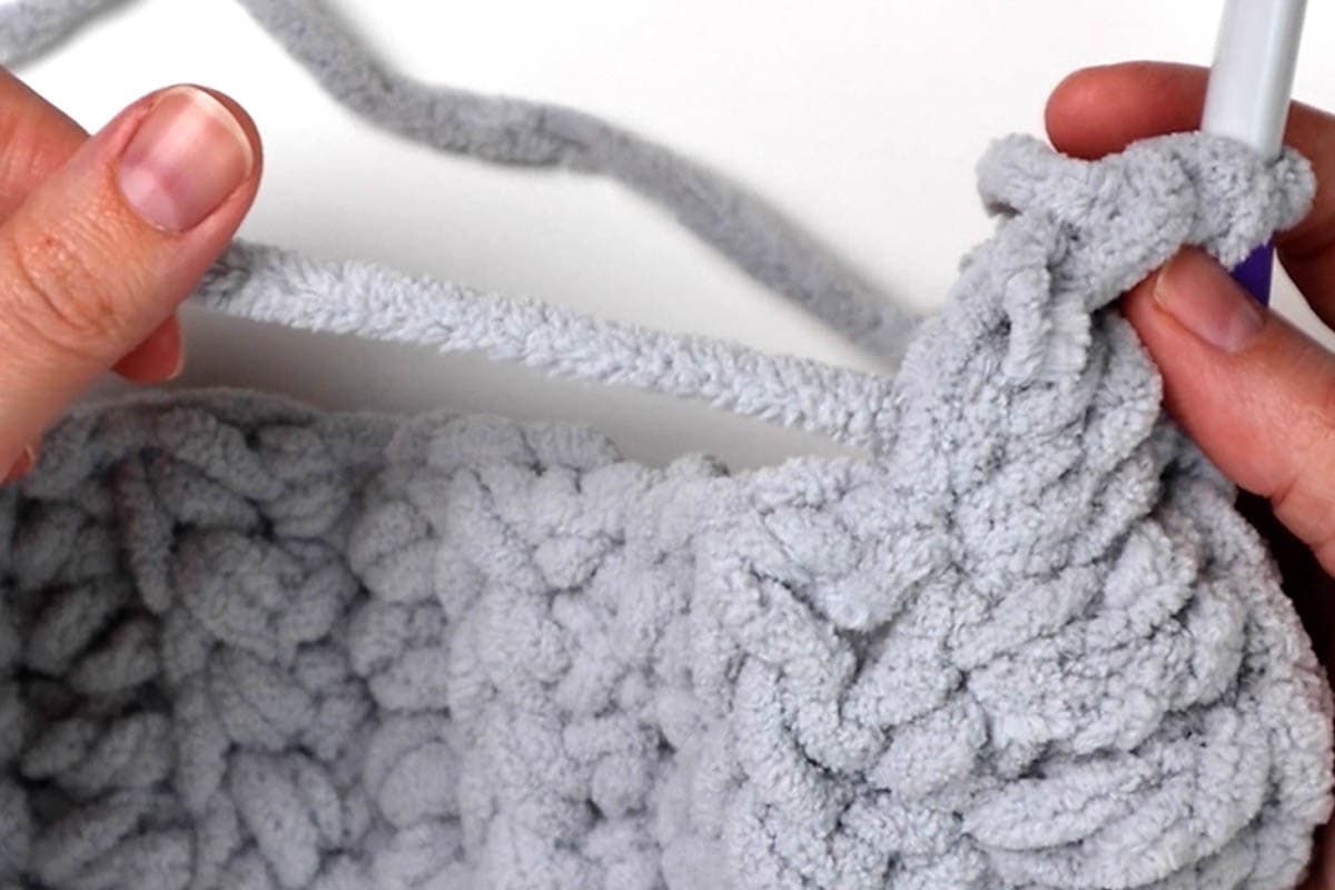 double crochet over the yarn tail so you don't have to weave it in later
