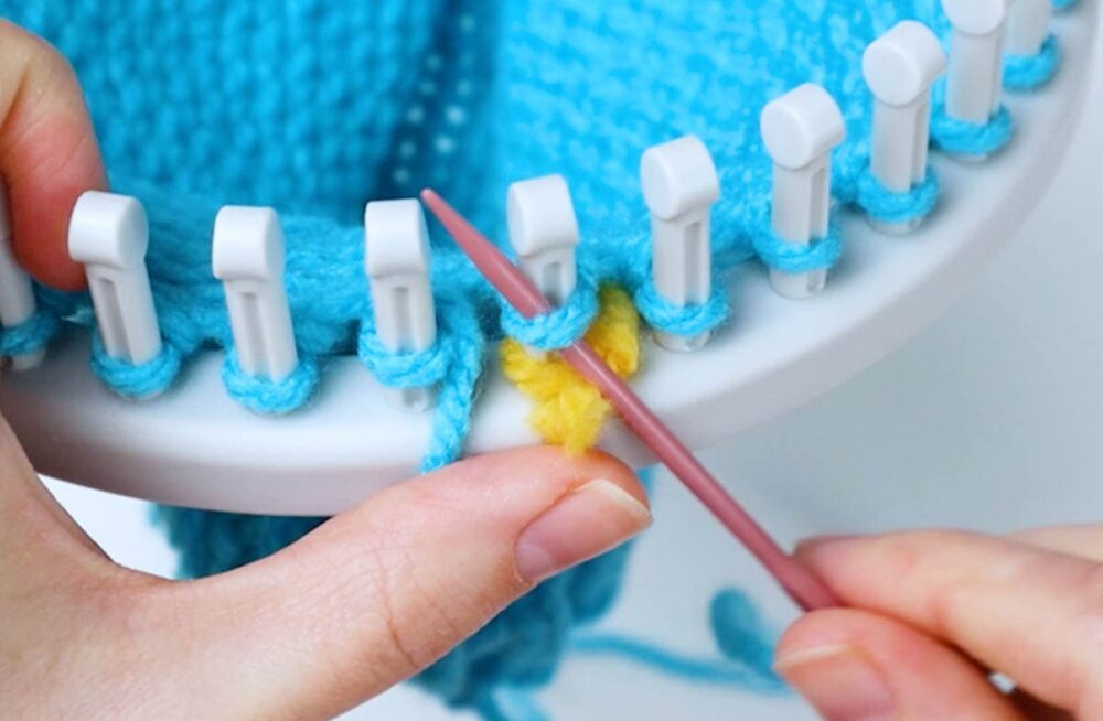 insert the needle up through the bottom of the loop on the first peg
