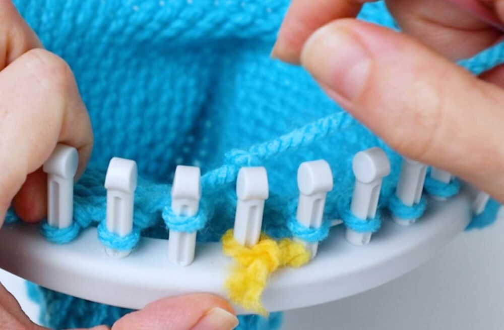 pull the yarn through and take the loop off the peg