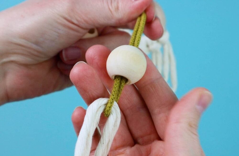 threading the bead onto the two center cords