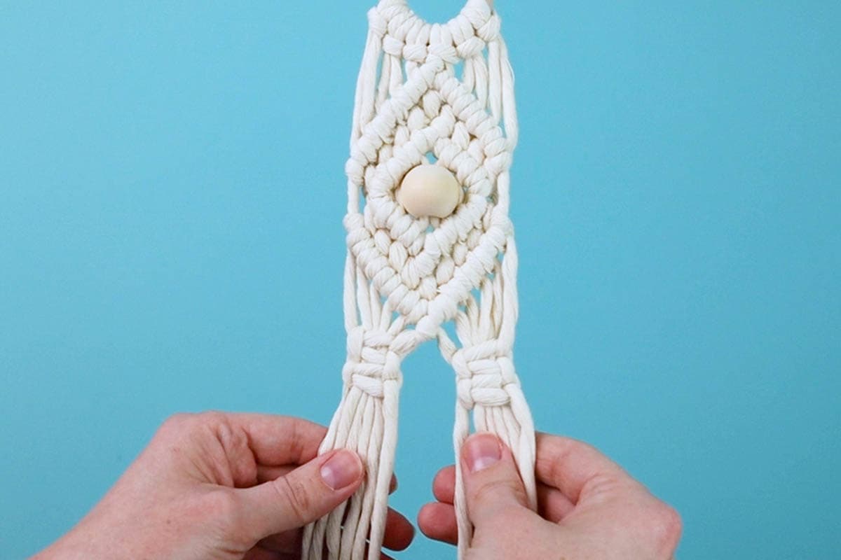 tie two square knots on each side of the macrame hat holder