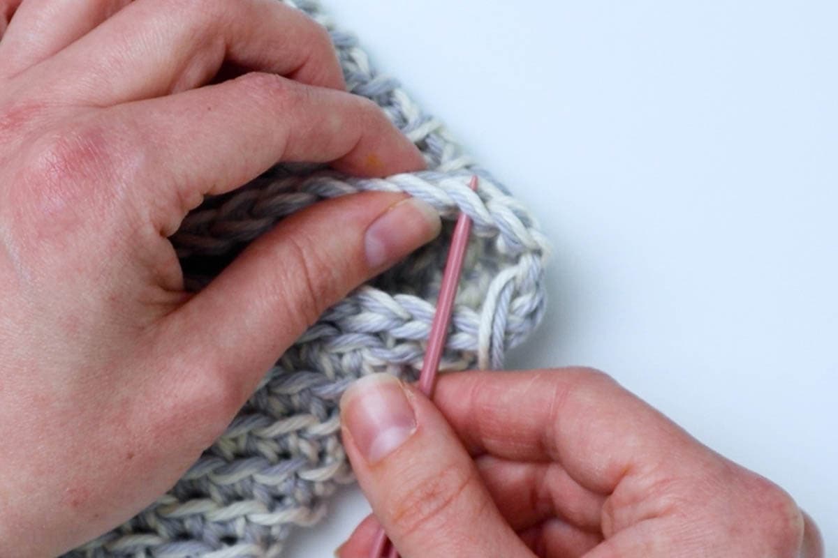 insert the needle under the next stitch across the opening