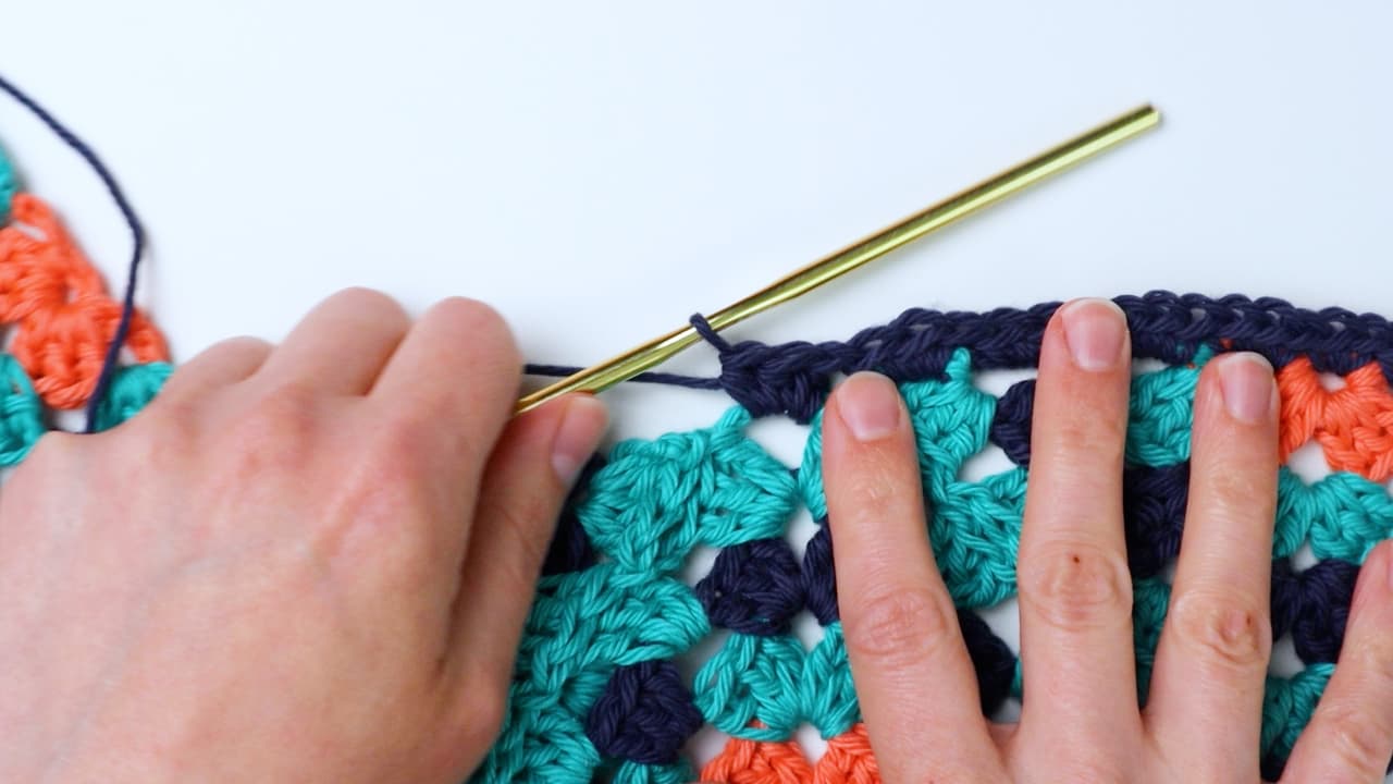 make 3 half double crochet in corner of granny squares on front border