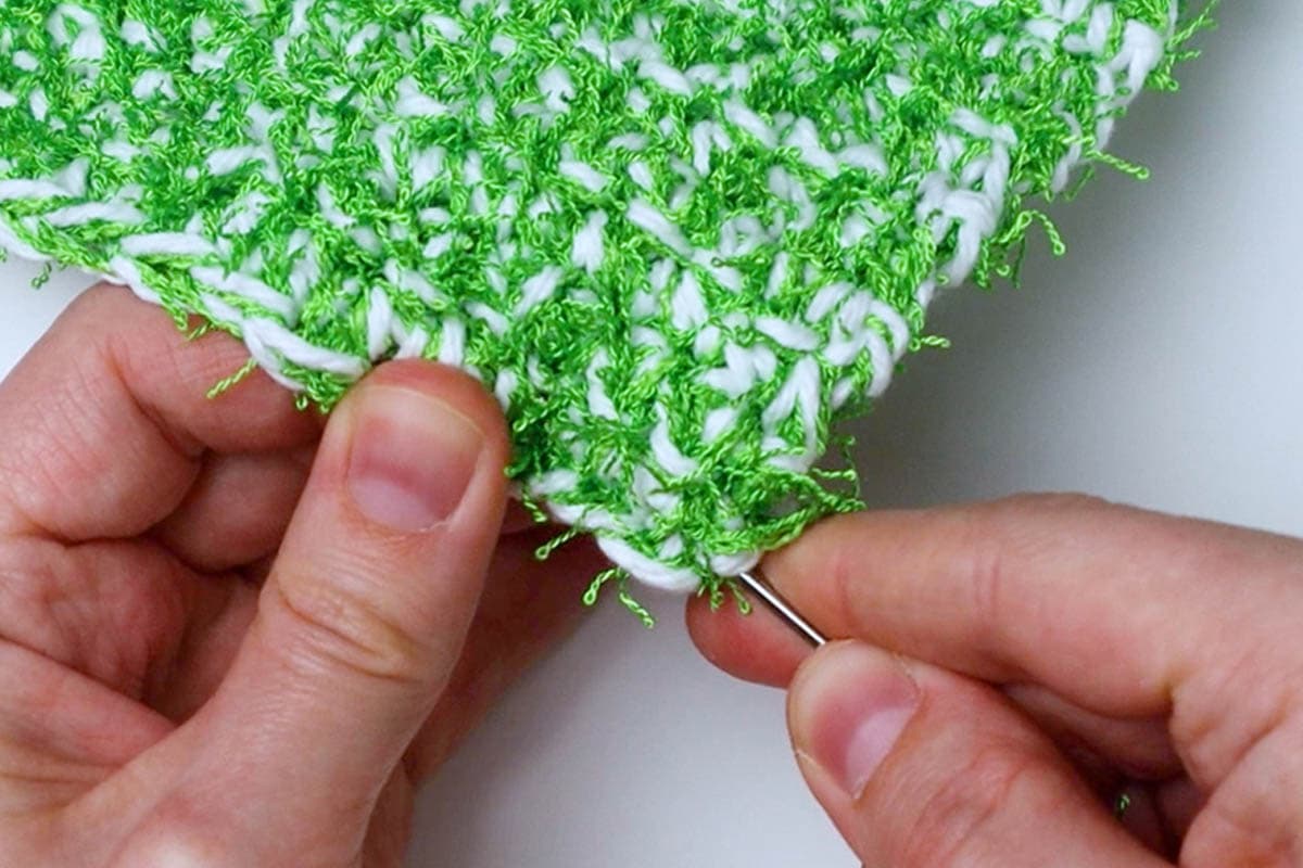 weave the yarn ends under several stitches using your yarn needle