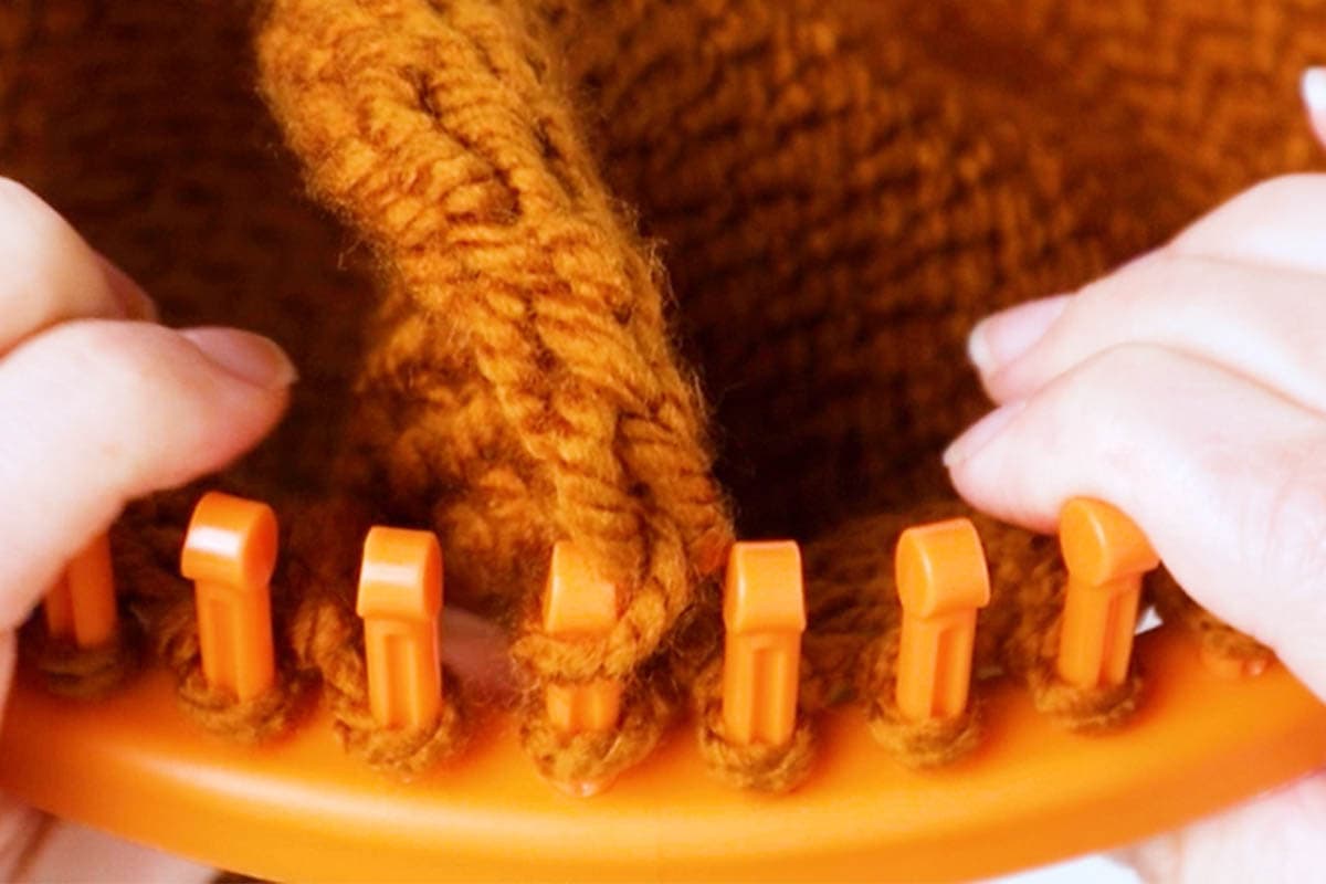 bring the first loop on the corner up and onto the corresponding peg