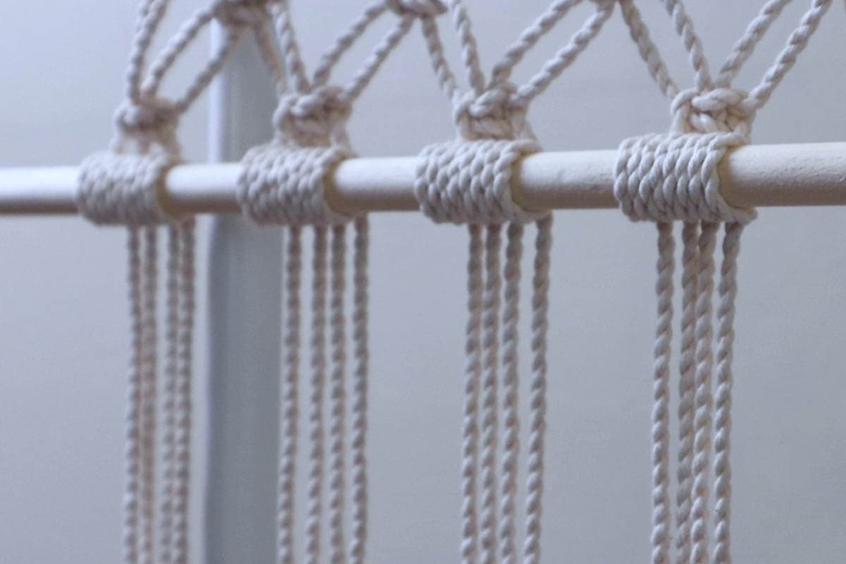 clusters of double half hitch knots holding the bottom dowel in place